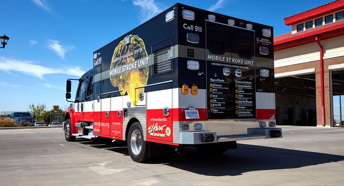 UMC's Mobile Stroke Unit parked outside a fire station under a clear blue sky, conveying readiness and urgency.