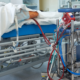 Specialized medical equipment connected to a patient during a vascular treatment procedure in a hospital setting.