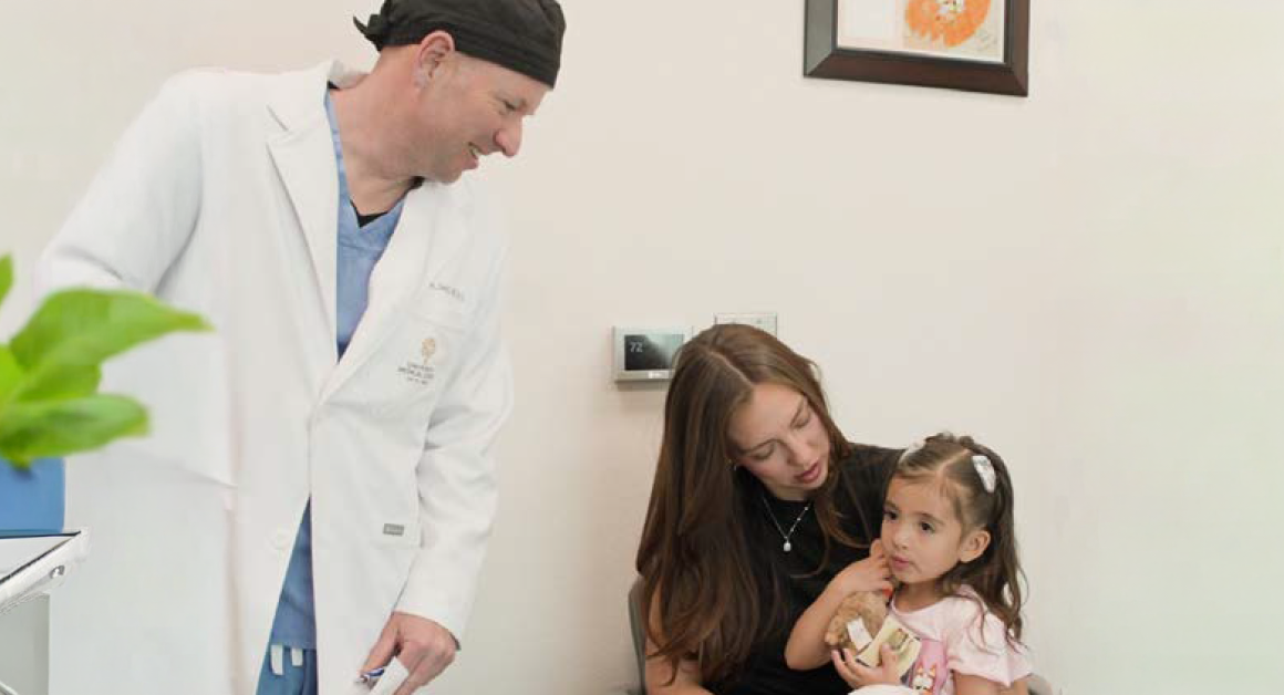 UMC healthcare provider meeting with a mother and young child during a pediatric cleft care appointment.