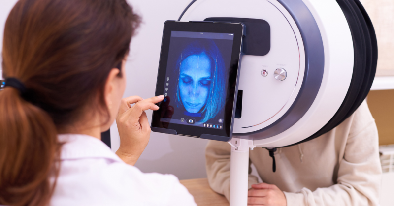 A dermatologist checking the skin of a person through a Skin Analysis Machine.