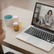 A sick patient having a telehealth call with a health professional over a computer.