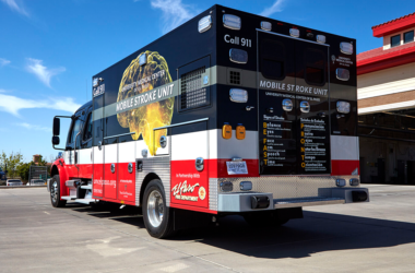 UMC's Mobile Stroke Unit parked outside a fire station under a clear blue sky, conveying readiness and urgency.