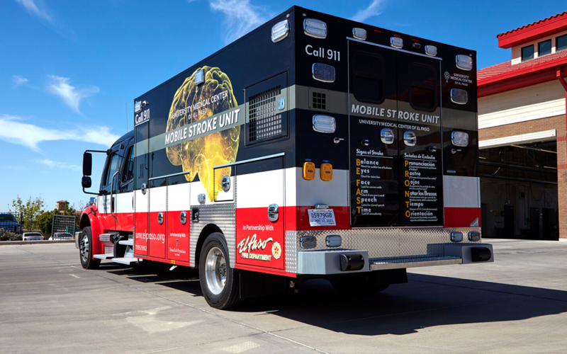 UMC's Mobile Stroke Unit parked outside a fire station under a clear blue sky, conveying readiness and urgency.