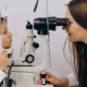 Eye doctor examines a young child's eyes using a slit lamp during an eye exam.