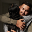 Two people embrace in a comforting hug, offering emotional support.