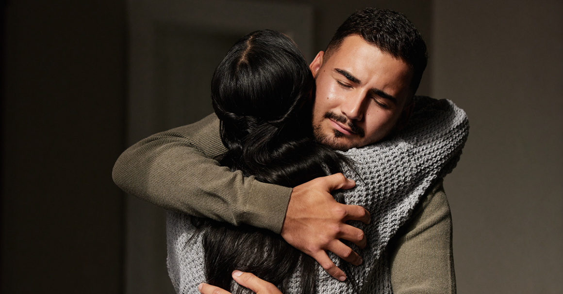 Two people embrace in a comforting hug, offering emotional support.