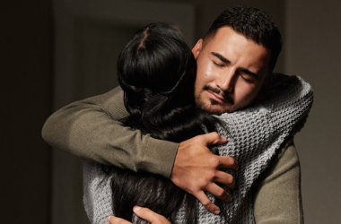 Two people embrace in a comforting hug, offering emotional support.
