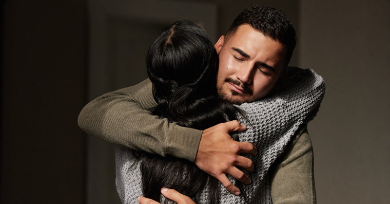 Two people embrace in a comforting hug, offering emotional support.