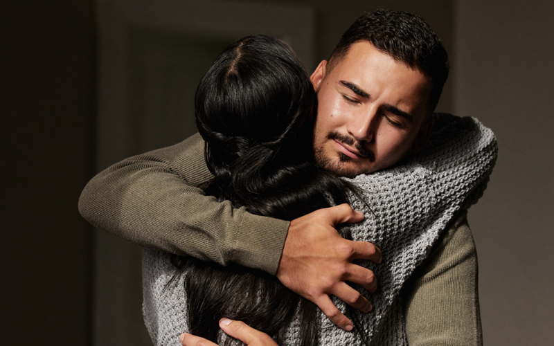 Two people embrace in a comforting hug, offering emotional support.