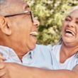 Older couple laughing together outdoors, reflecting connection, well-being, and healthy aging.