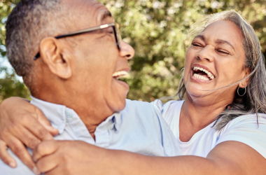 Older couple laughing together outdoors, reflecting connection, well-being, and healthy aging.