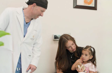 UMC healthcare provider meeting with a mother and young child during a pediatric cleft care appointment.