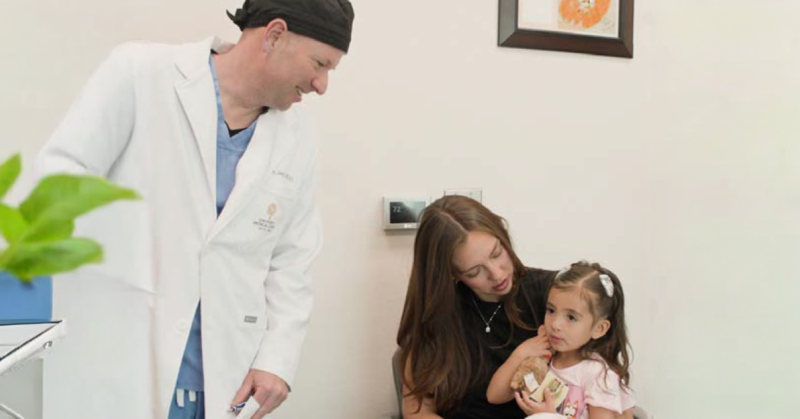 UMC healthcare provider meeting with a mother and young child during a pediatric cleft care appointment.