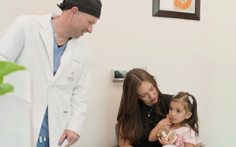 UMC healthcare provider meeting with a mother and young child during a pediatric cleft care appointment.
