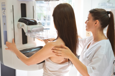 A healthcare professional assists a patient during a mammogram screening.